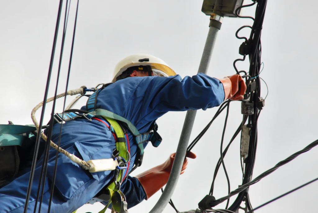 Technicien intervenant sur un réseau électrique en hauteur