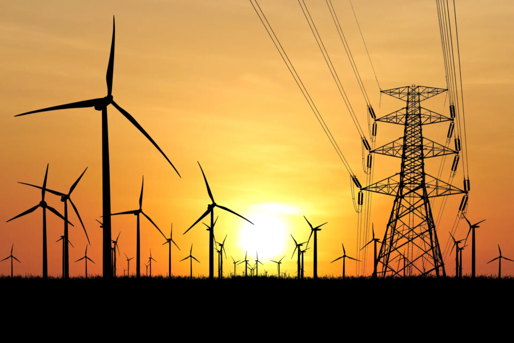 Pylônes électriques et éoliennes symbolisant la production et le transport d’énergie en France, en lien avec la CSPE 2026 et la fiscalité énergétique.