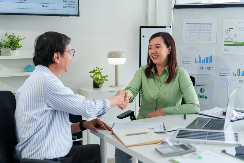 Un responsable de syndic échange avec une conseillère en énergie pour négocier le contrat d’électricité d’une copropriété.