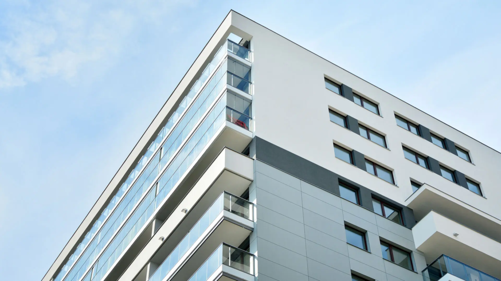 Façade d'immeuble blanche, avec vitres et balcons