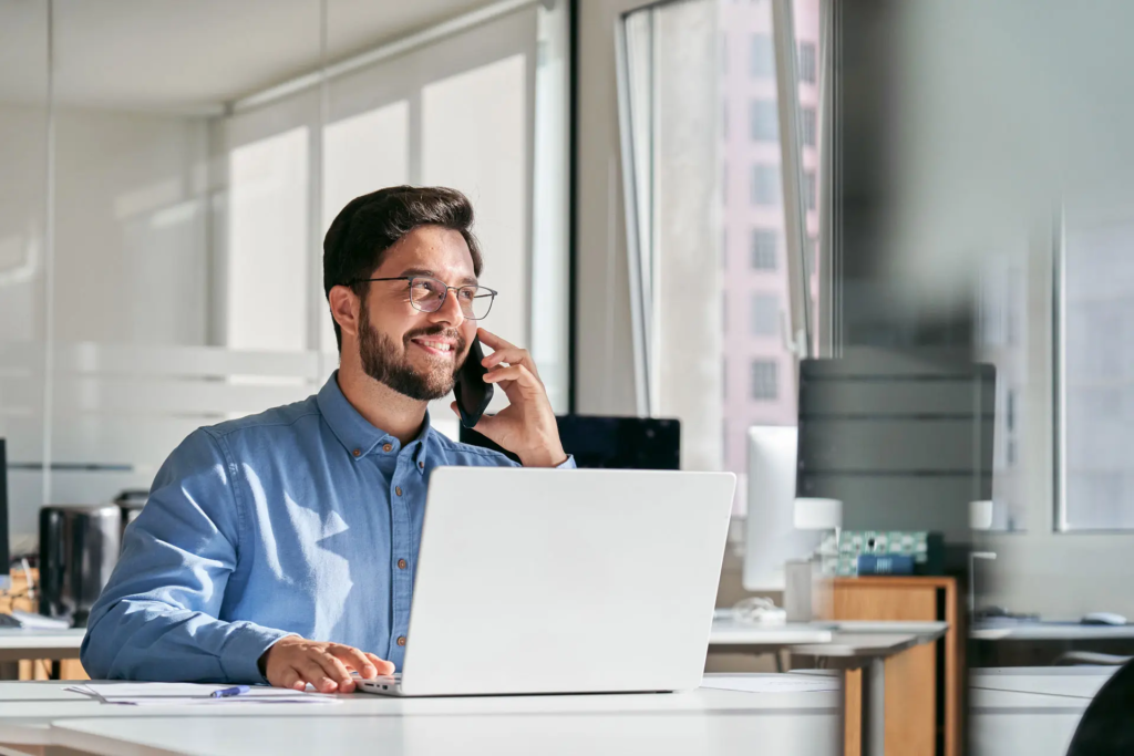 Expert énergie devant son ordinateur et au téléphone, à son poste de travail.