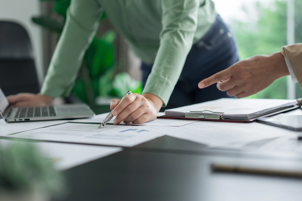 Collaboration professionnelle autour de documents et d’un ordinateur pour analyser des données