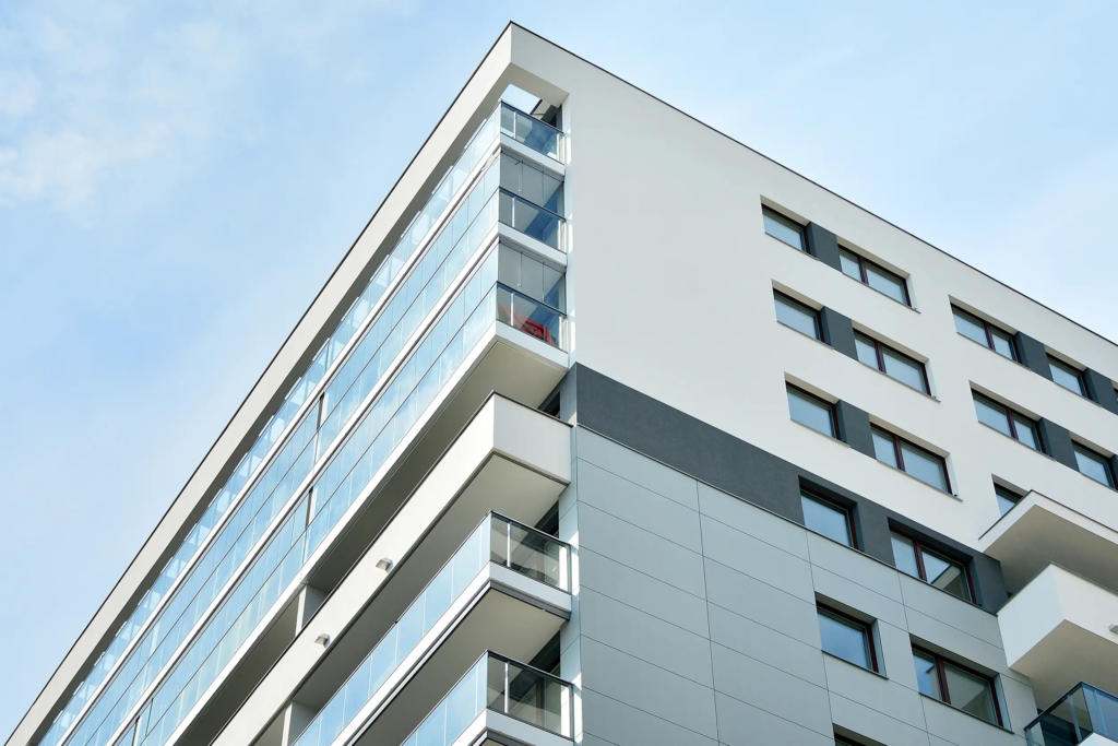 Façade d'immeuble blanche, avec vitres et balcons