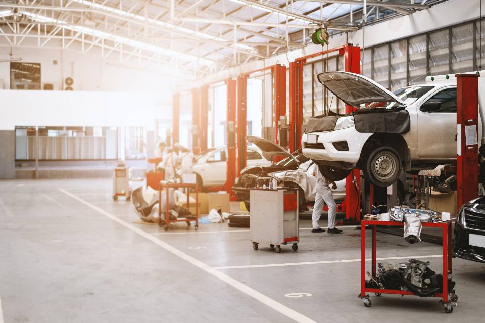Technicien dans un atelier automobile optimisant les équipements pour réduire la facture d’énergie du garage.