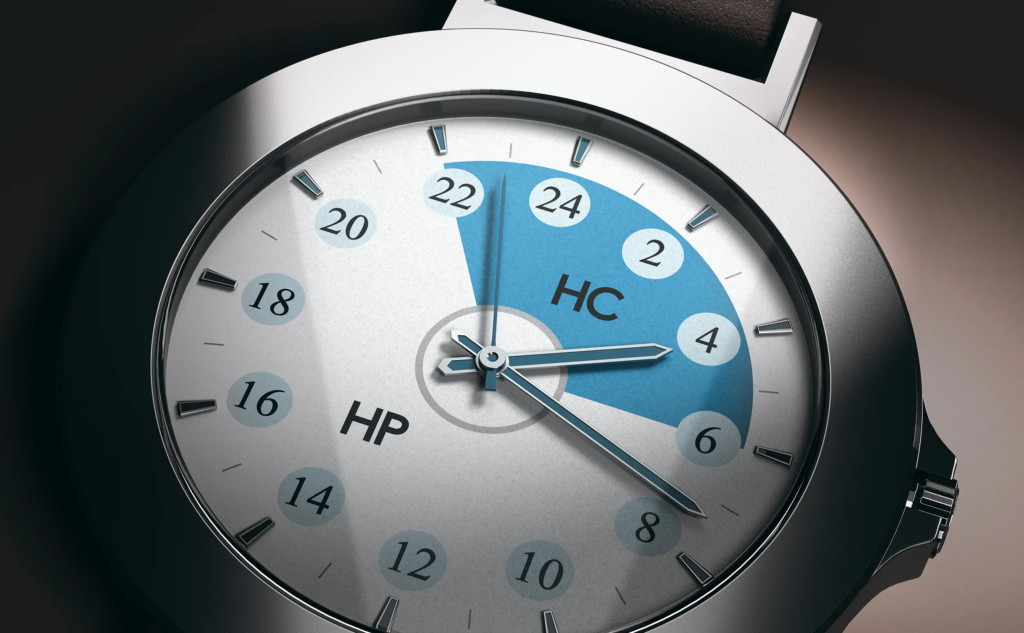 Montre à aiguilles dont le cadran est divisé en zones heures pleines et heures creuses, symbolisant l’impact des périodes horaires sur le coût de l’électricité.