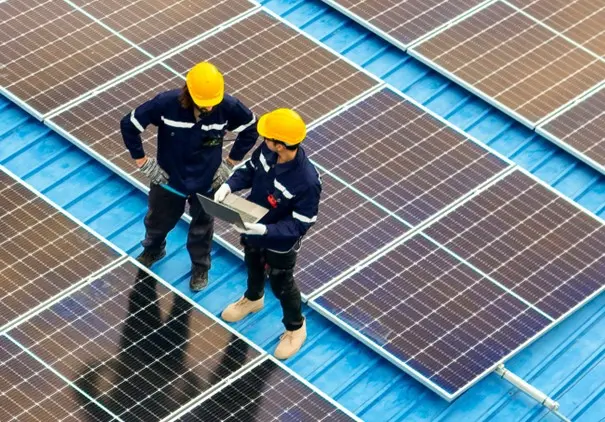 Deux hommes en tenue de chantier contrôlent la pause de panneau solaire sur un toit
