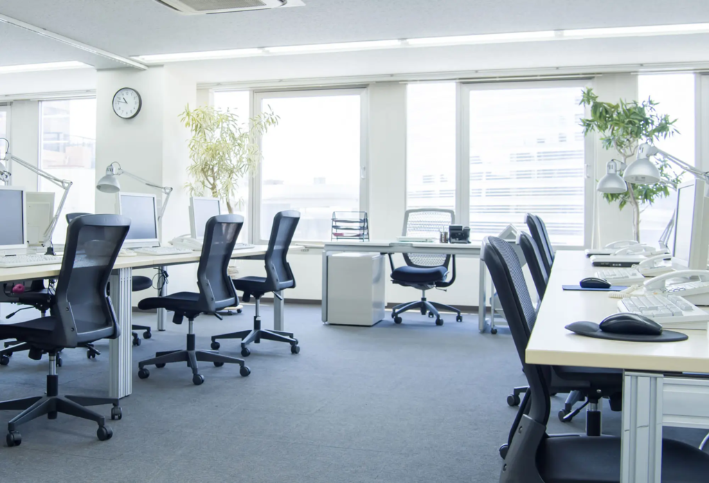 Bureaux Alliance des Énergies, munis de chaises et de bureaux, avec des fenêtres lumineuses en second plan.