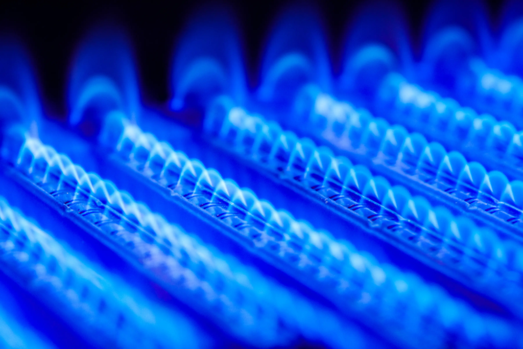 Brûleur de gaz avec flamme bleue illustrant les contrats de gaz indexés sur les marchés de gros