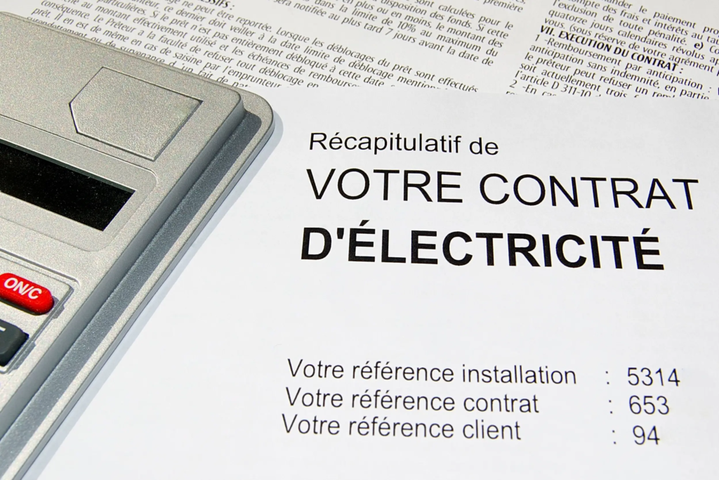 Contrat d’électricité d’entreprise posé sur un bureau avec une calculatrice, illustrant l’analyse des coûts pour réduire sa facture d’électricité.