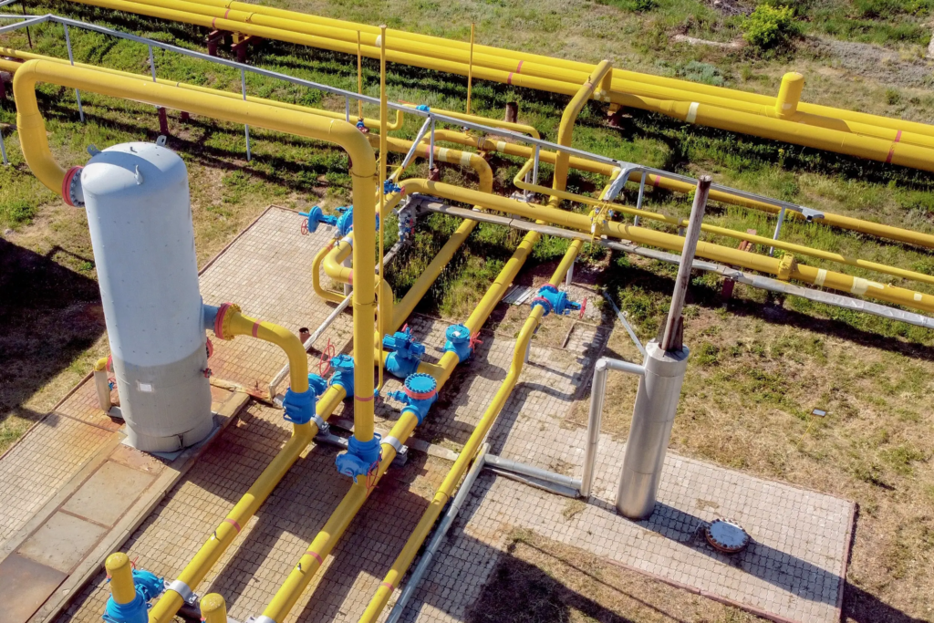 Installation gazière industrielle avec canalisations et vannes, illustrant les coûts régulés liés au transport et au stockage du gaz naturel.