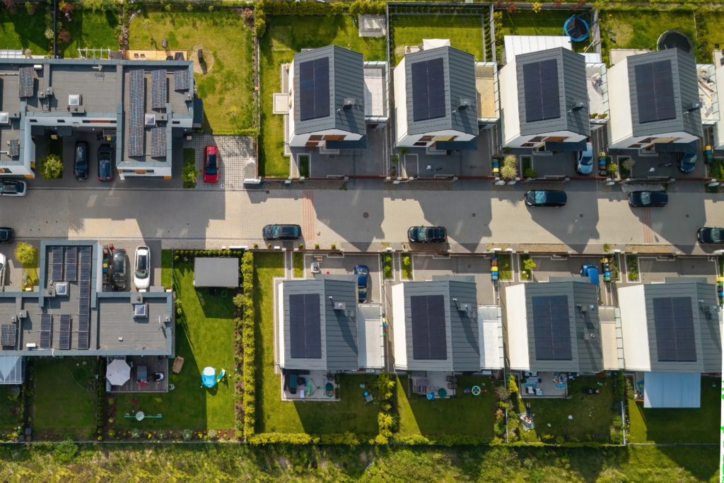 Vue aérienne d’un quartier résidentiel équipé de panneaux solaires, illustrant l’autoconsommation collective.