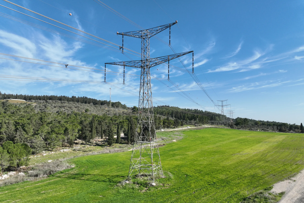 Vue aérienne par drone de pylônes et lignes à très haute tension traversant des parcelles agricoles — infrastructure du réseau de transport d'énergie en France