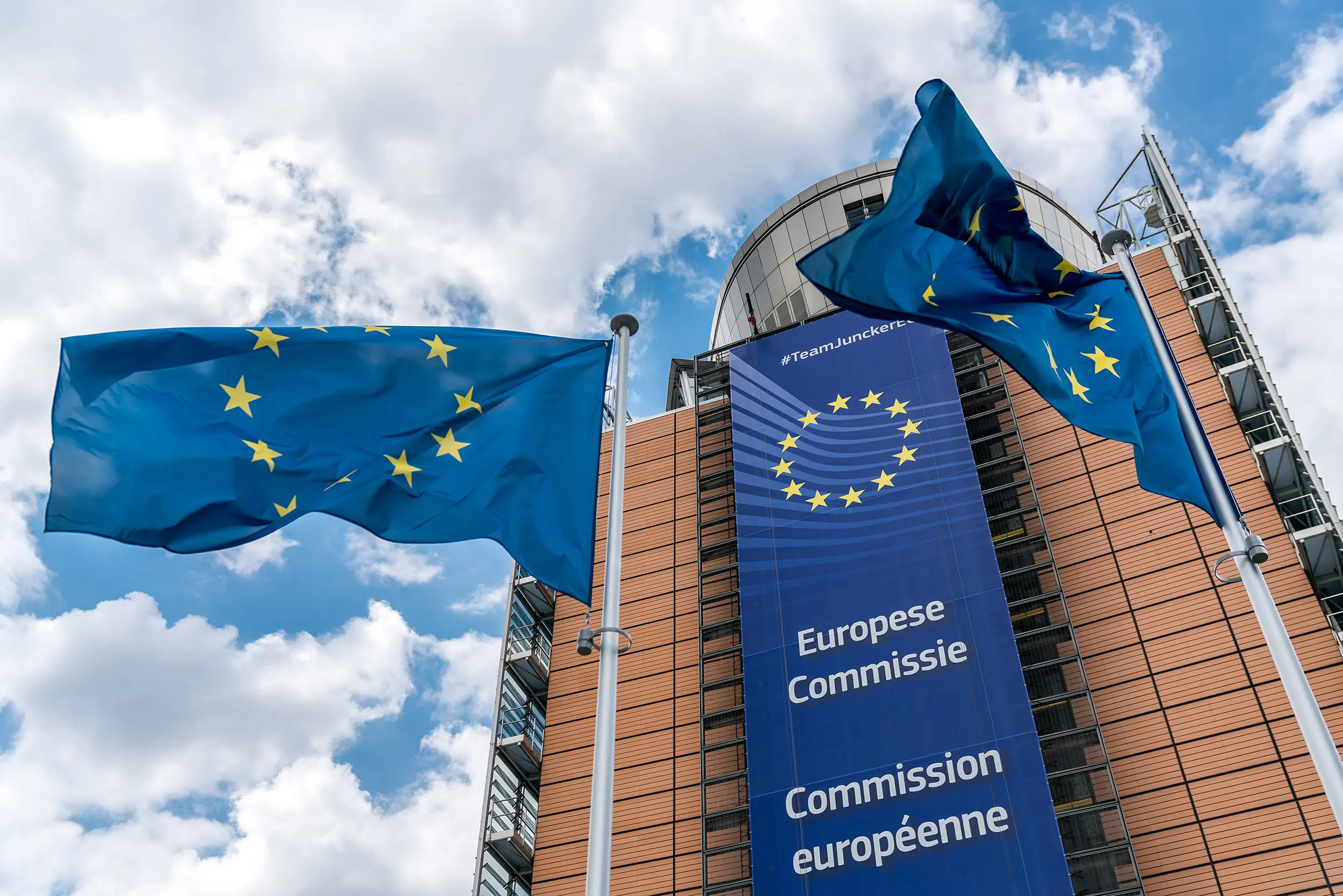 âtiment de la Commission européenne à Bruxelles, drapeaux européens flottant devant la façade